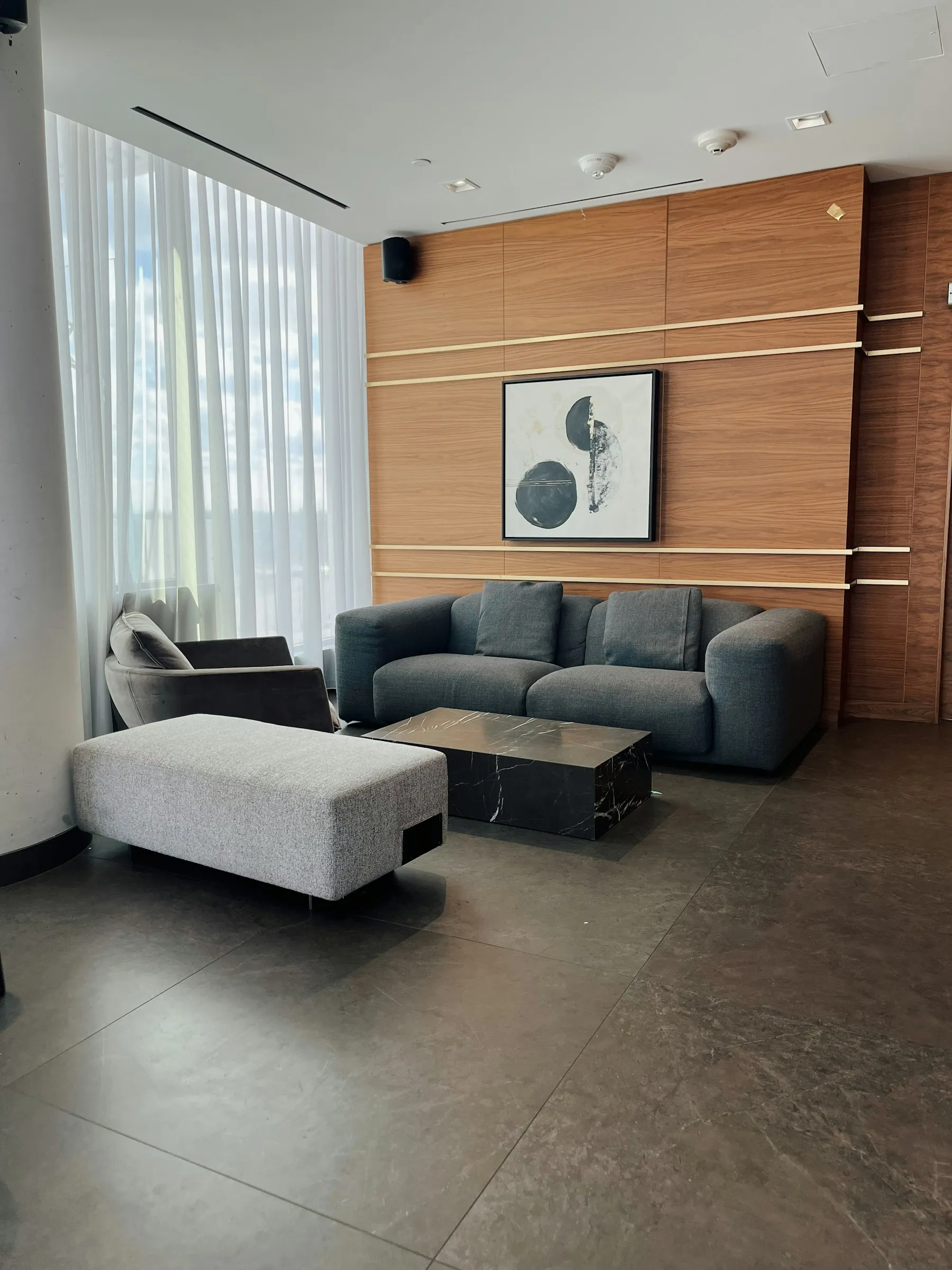 The living room with a dark sofa against a panelled timber wall