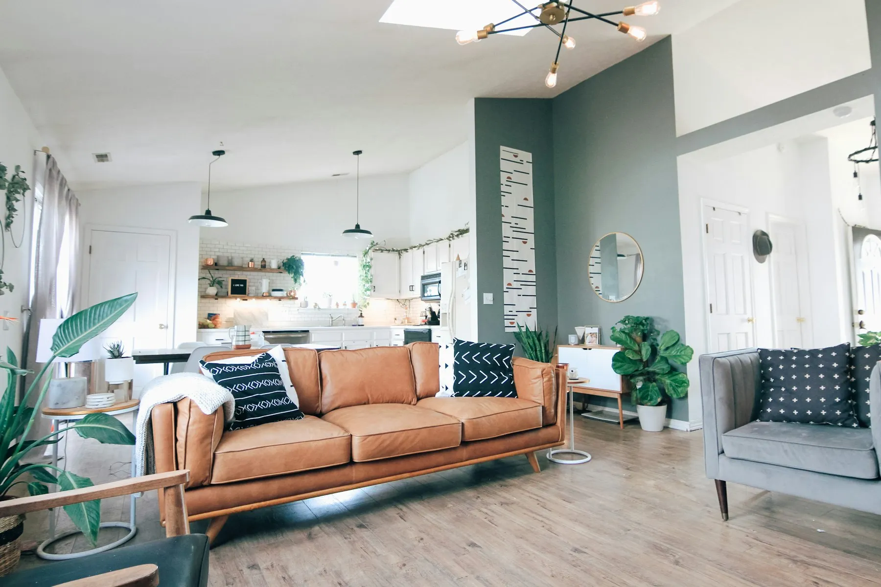 The open-plan living room with a terracotta sofa and white walls